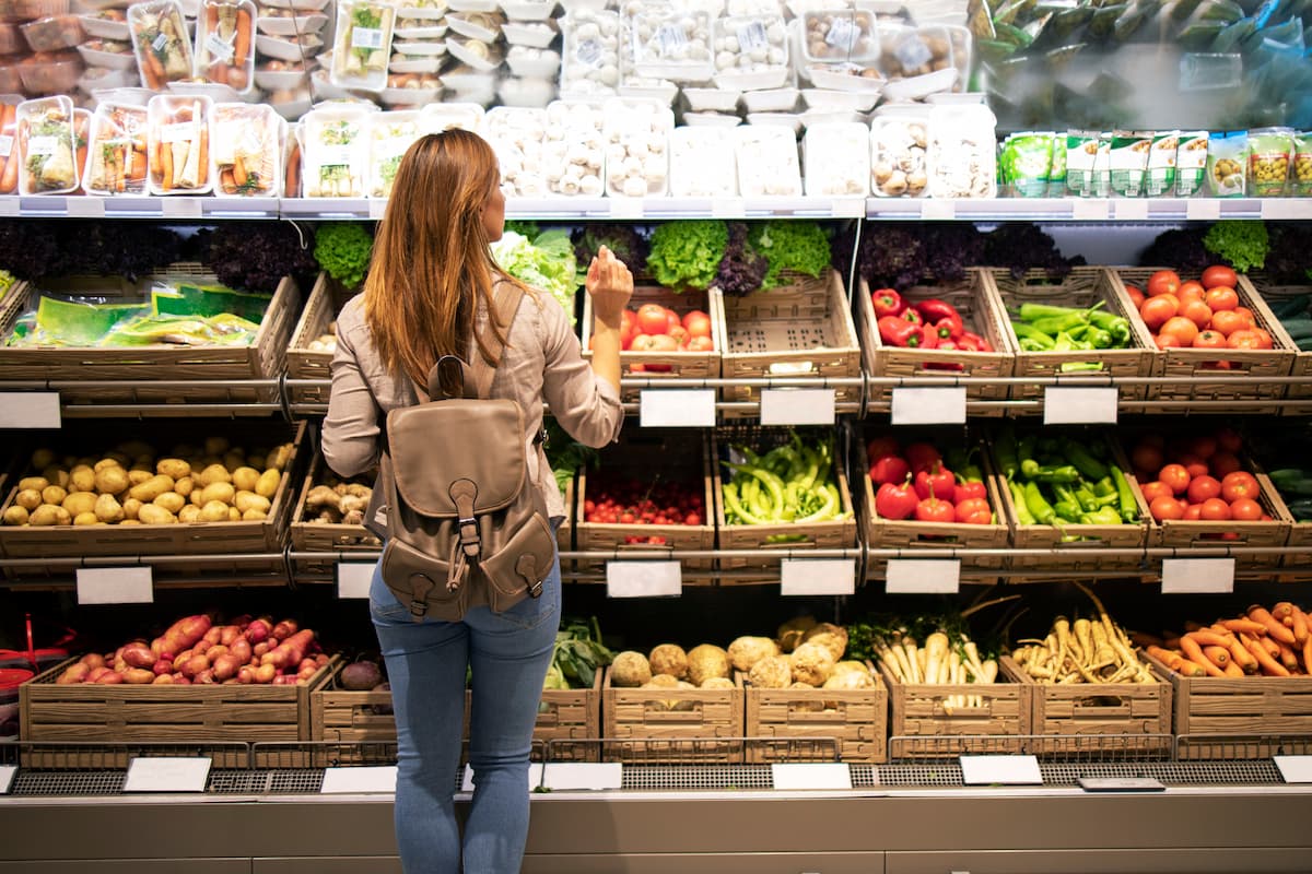 good-looking-woman-standing-front-vegetable-shelves-choosing-what-buy (1)